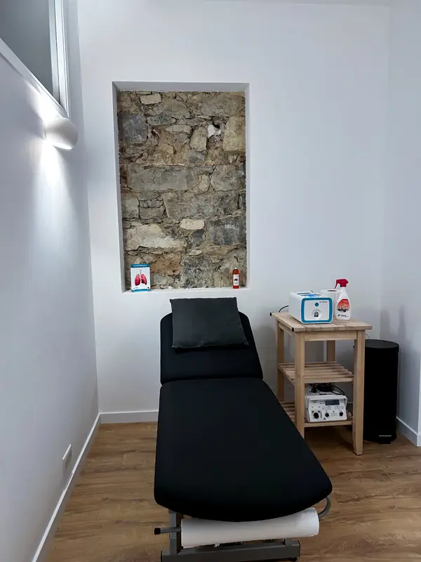 Une salle de soin, table et mur de pierre apparent