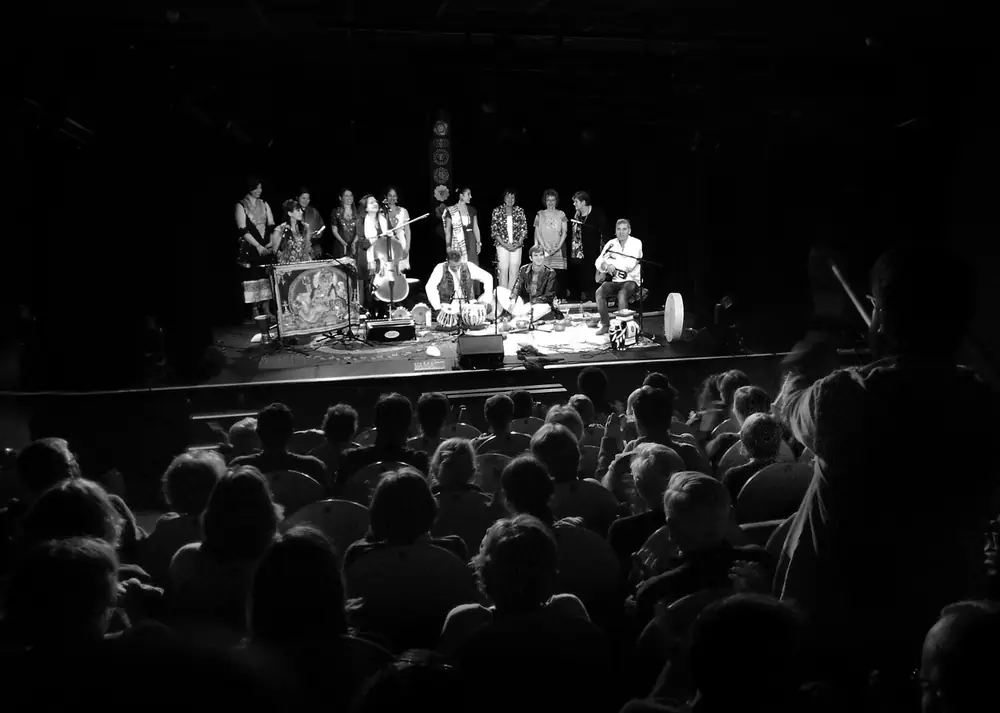 Une chorale et des musiciens sur scène, devant le public