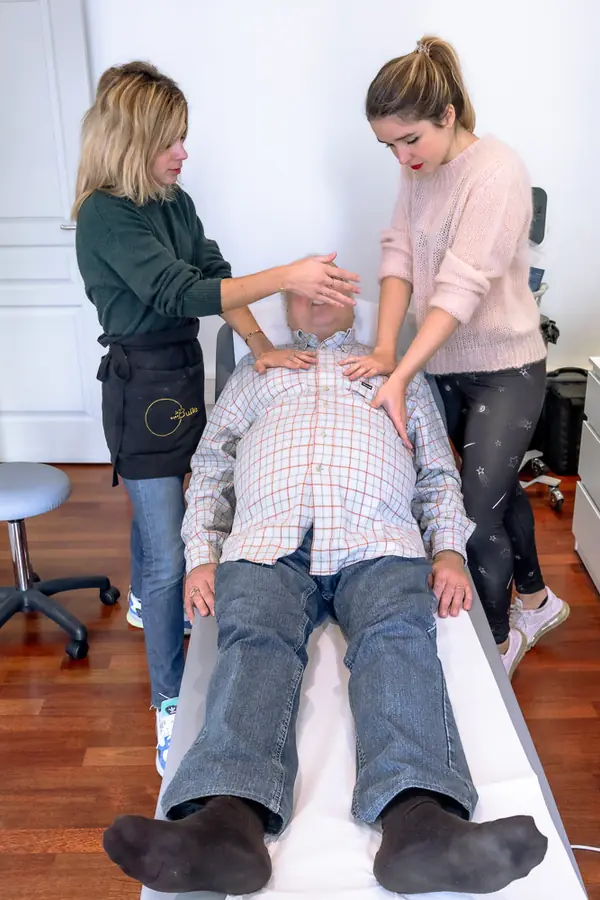 Un patient accompagné par deux kinésithérapeutes pendant une séance de drainage respiratoire à La Bulle