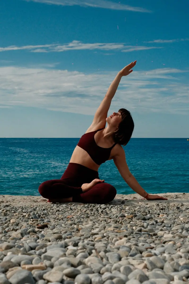 Une posture de yoga sur les galets, face à la mer
